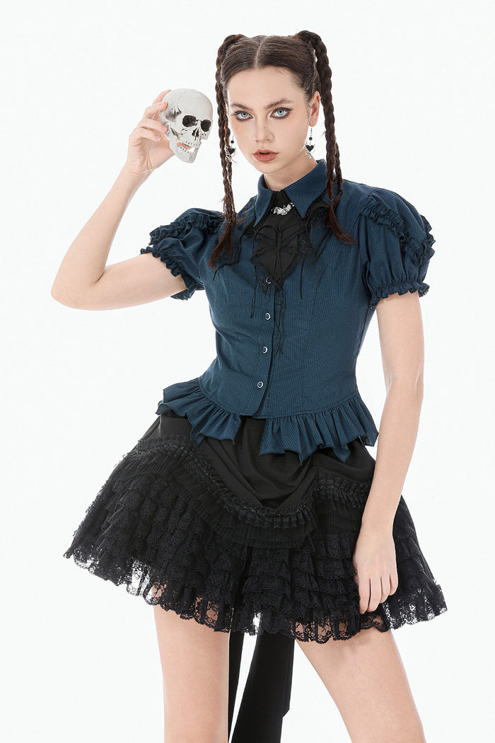 Woman in a gothic outfit holding a skull against a white background