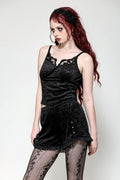 A woman wearing a black velvet tank top with adjustable shoulder straps and embroidered details.