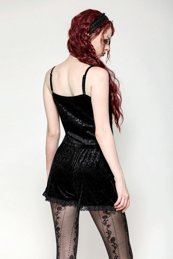 Woman in black velvet top with sheer stockings on a white background