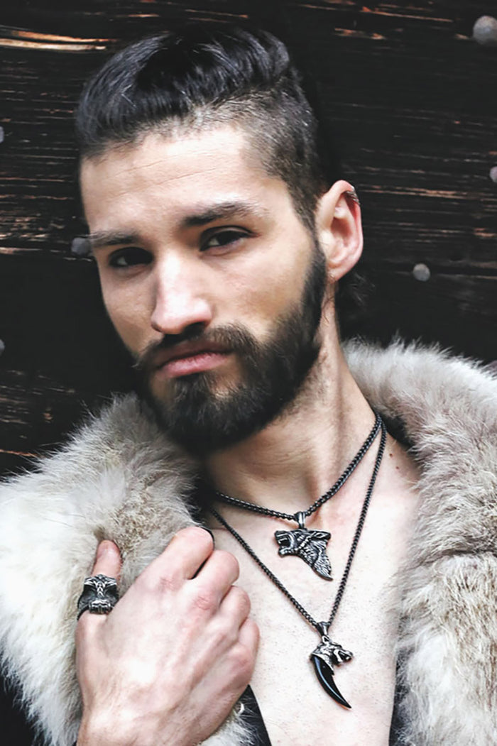 Silver wolf head werewolf pendant on a chain against a white background
