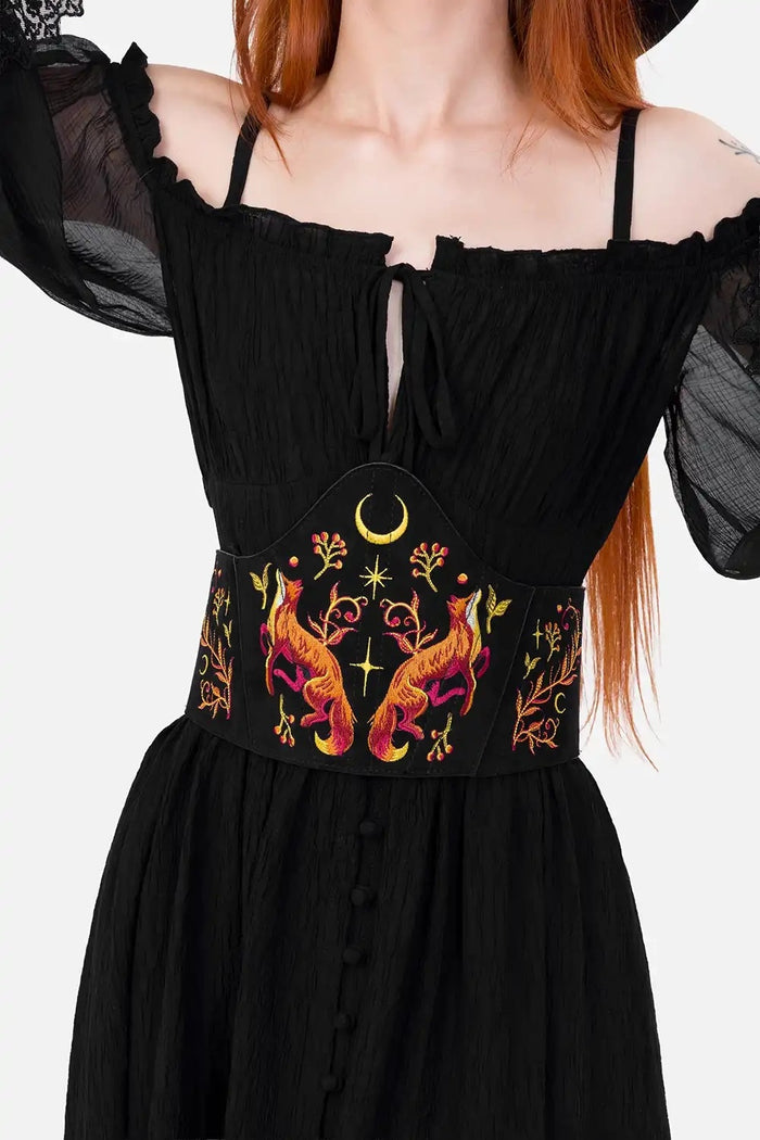 Black corset with colorful embroidery on a plain background