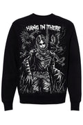 A black crewneck sweatshirt featuring a large white graphic print of a skeletal figure with wings and the text 'HANG IN THERE' across the chest, shown against a plain white background.