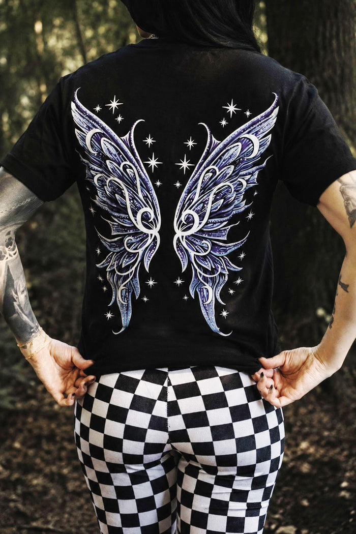 Person wearing a black t-shirt with fairy wings design outdoors