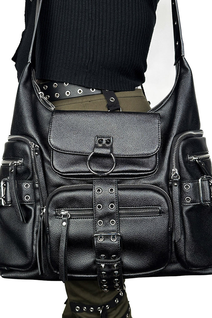 Black leather bag with studs and buckles on a plain background