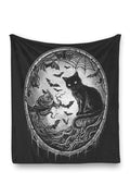 Black throw blanket made of fleece with a cat, bats, and spiderweb design on a white background