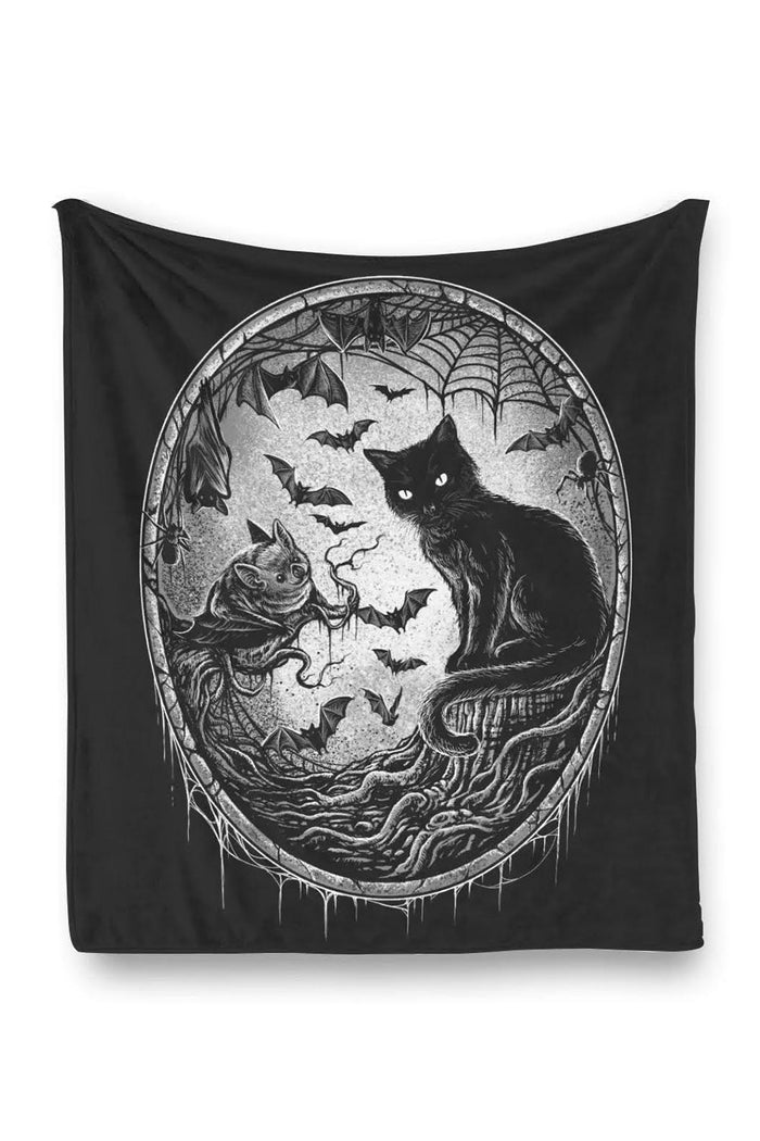 Black throw blanket made of fleece with a cat, bats, and spiderweb design on a white background