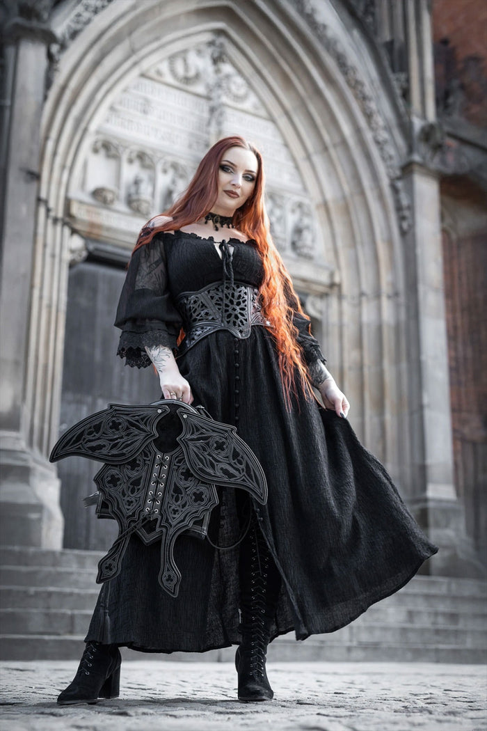 Model holding gothic moth wing backpack