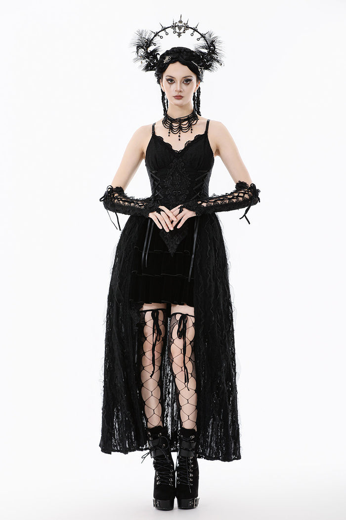 Woman in a black gothic dress with lace sleeves and accessories on a white background