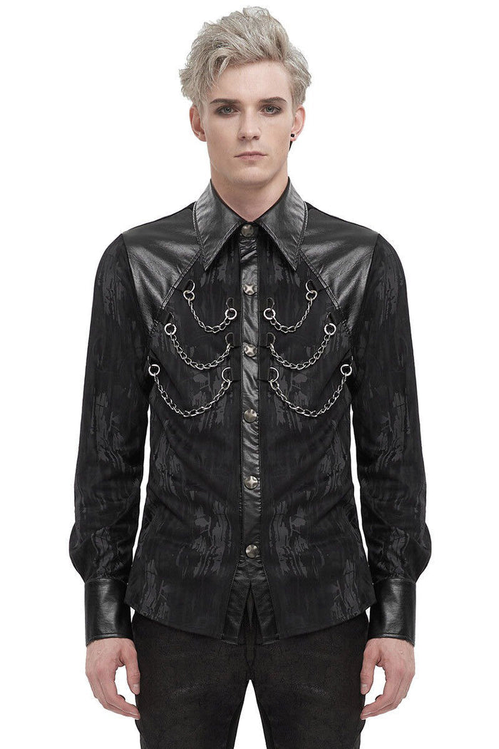 Man wearing a black, ornate shirt with leather accents on a white background