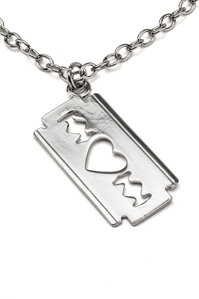 Silver razorblade-shaped pendant with heart and star cutouts on a chain against a white background