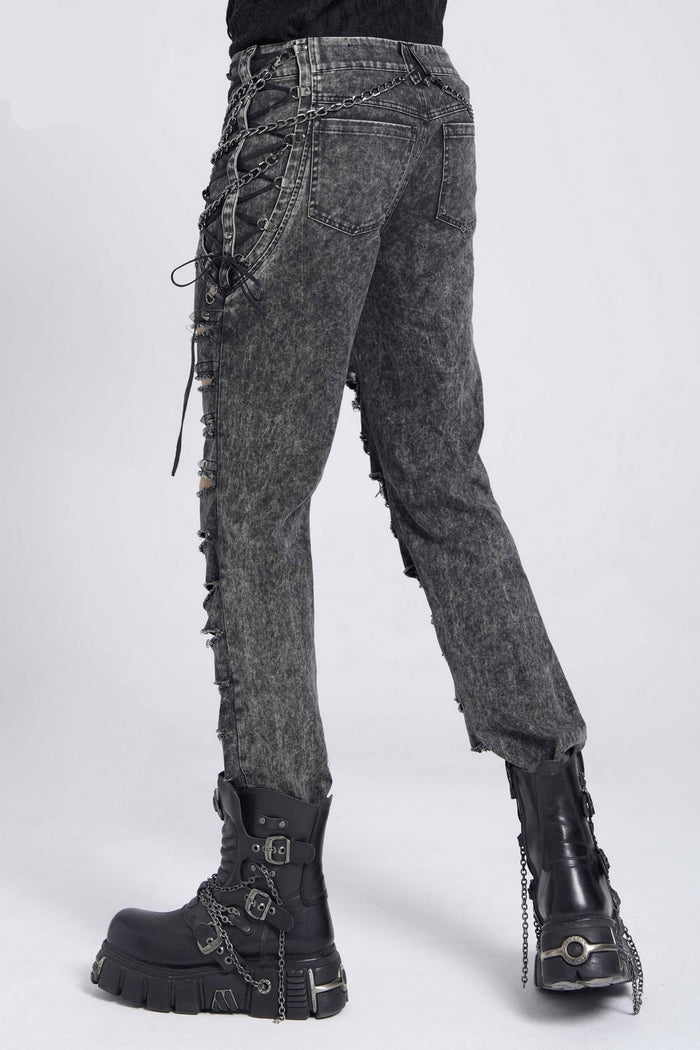 Dark gray distressed jeans with lace-up details worn by a person on a white background