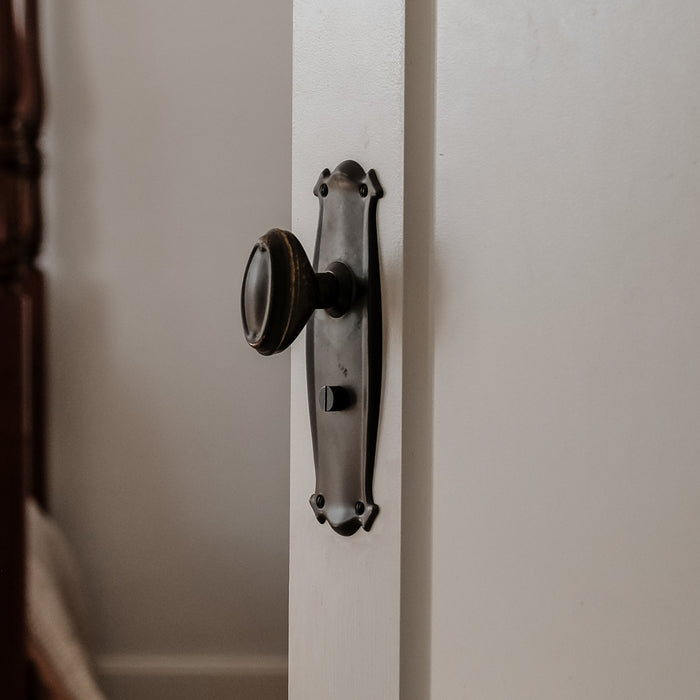 Detail TradCo Bungalow Door Knob Long Backplate Privacy Set Antique Brass 0830KPRIV60 - The Blue Space