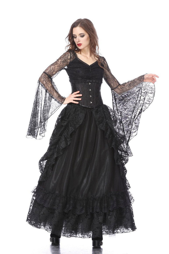 Woman wearing a black gothic-style dress with sheer sleeves on a white background
